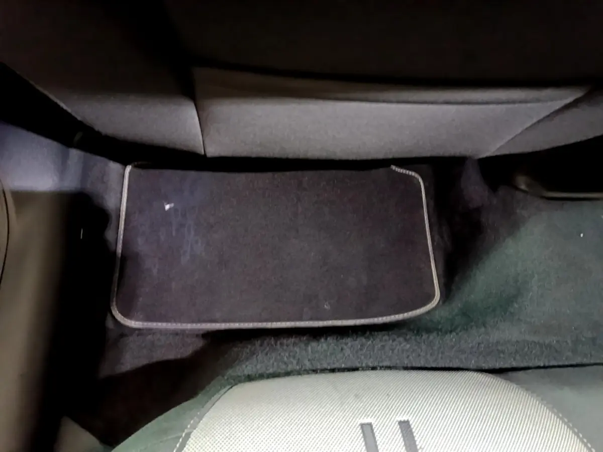 Vue du sol arrière côté conducteur avec tapis noir dans une SEAT LEON gris clair 2022