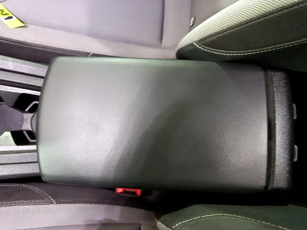 Accoudoir central noir entre les sièges avant du SEAT LEON gris clair, version 2022, vue intérieure rapprochée.