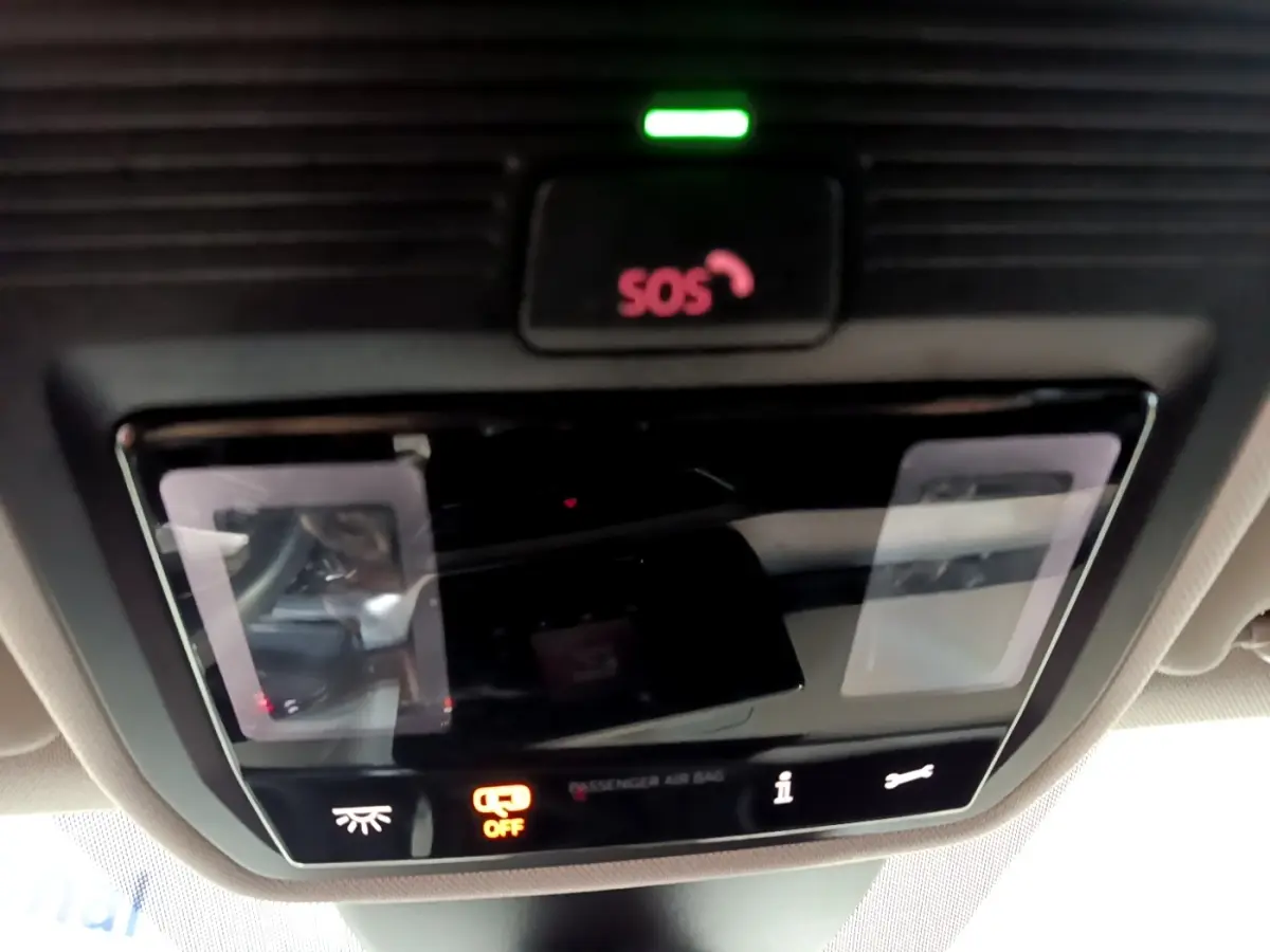 Panneau de commande intérieur avec bouton SOS illuminé en rouge sur SEAT Leon gris clair, vue du plafond cabine.