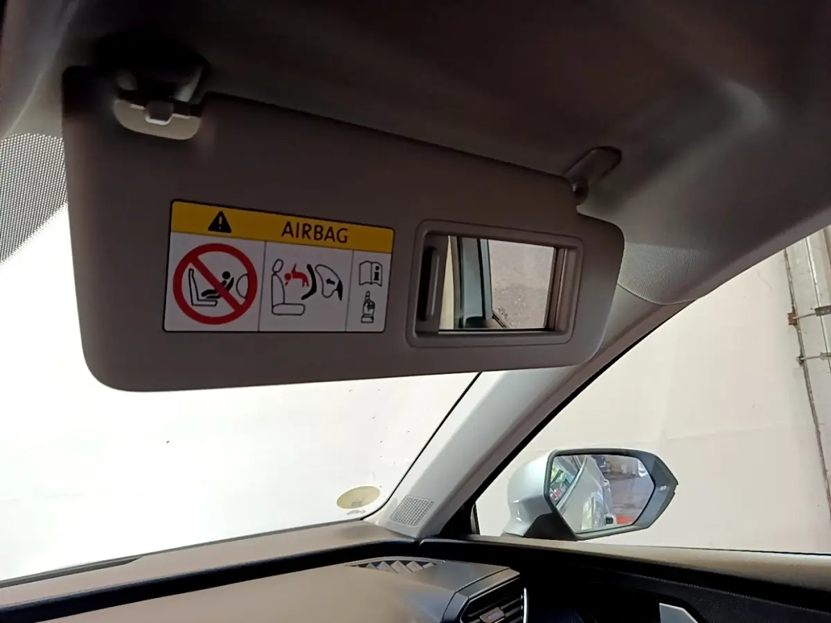 Vue intérieure côté conducteur du SEAT Leon gris clair 2022, avec pare-soleil et miroir intégré visible.