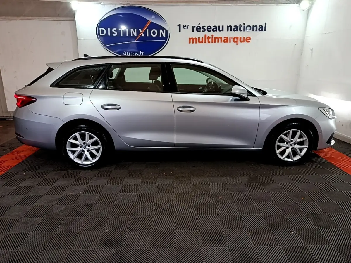 Vue latérale droite d'une SEAT LEON gris clair break 2022, stationnée en intérieur avec éclairage neutre.