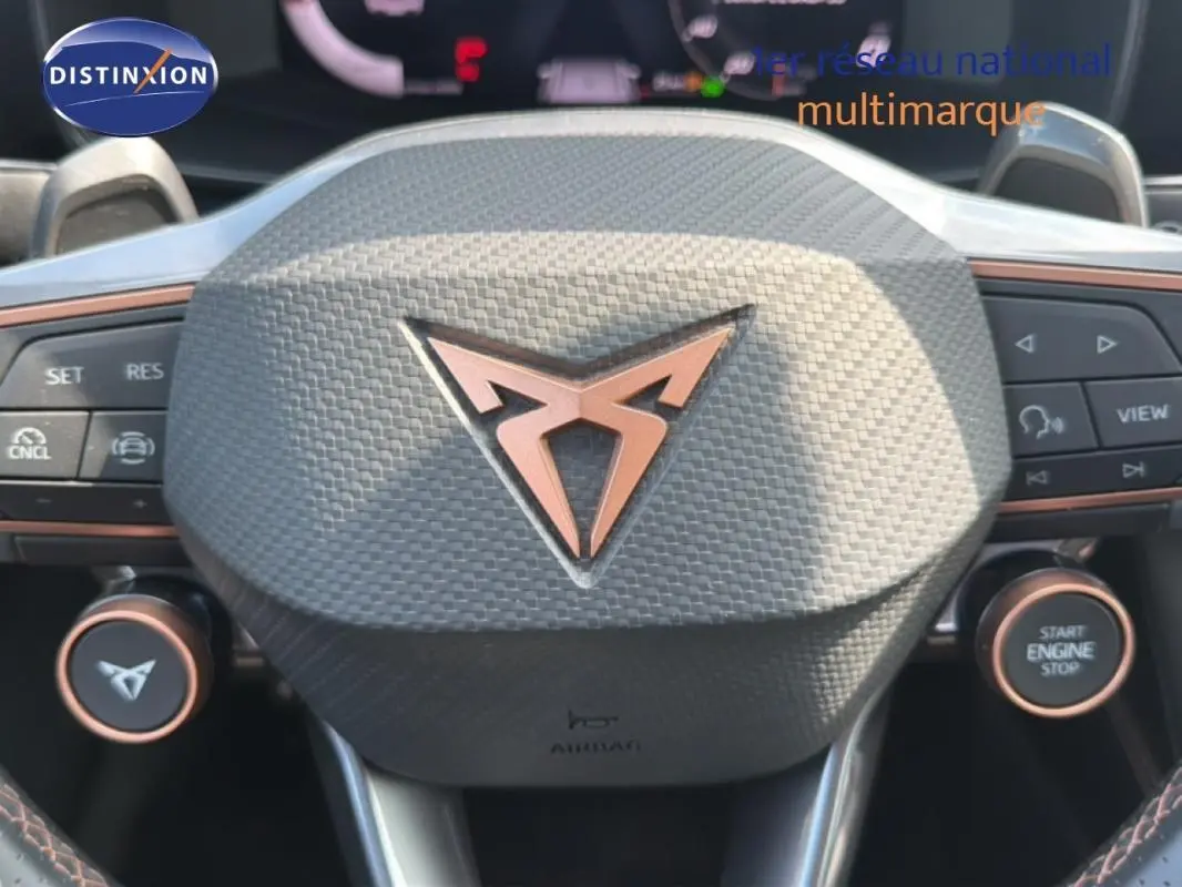 Gros plan sur le volant texturé gris foncé du CUPRA Formentor 2025 avec logo cuivre et commandes intégrées.