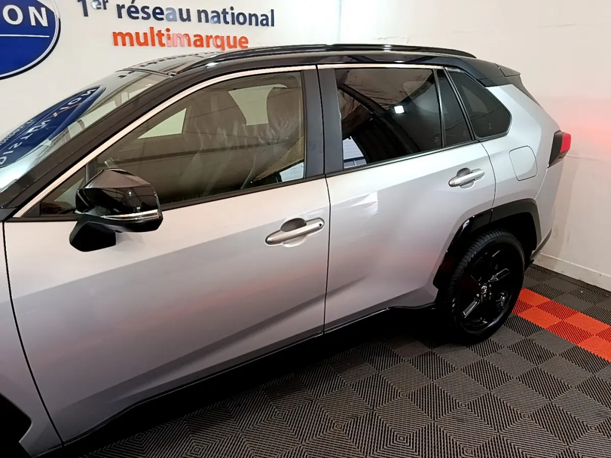 Profil côté gauche du Toyota RAV4 2WD gris clair 2019 avec rétroviseurs noirs et jantes noires.
