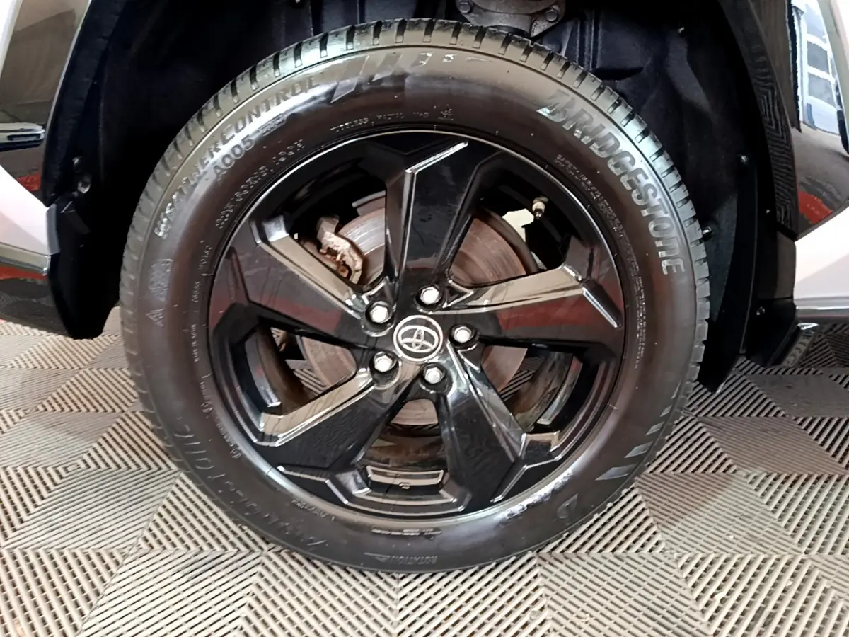 Gros plan sur la roue avant droite noire brillante du Toyota RAV4 gris clair 2WD 218ch Collection 2019.
