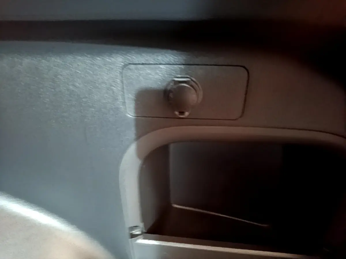 Prise 12V dans le coffre du Toyota RAV4 2WD gris clair, détail intérieur du rangement arrière.