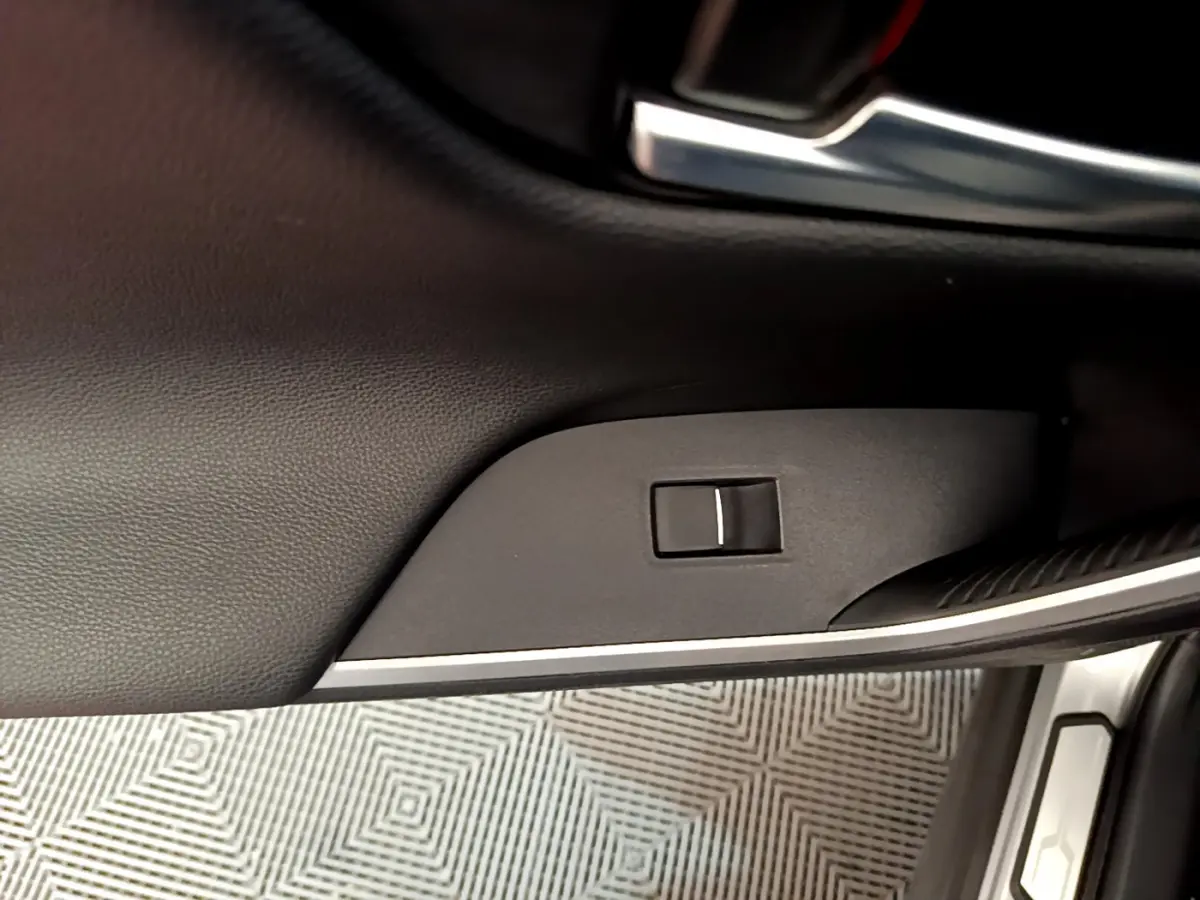 Gros plan sur la commande de verrouillage de porte côté conducteur dans l'habitacle noir du Toyota RAV4 gris clair 2019.