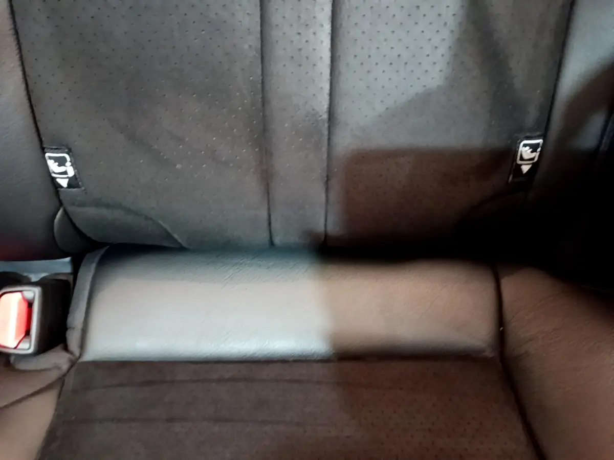 Gros plan sur la banquette arrière noire perforée du Toyota RAV4 2WD 218ch Collection avec ceintures visibles.