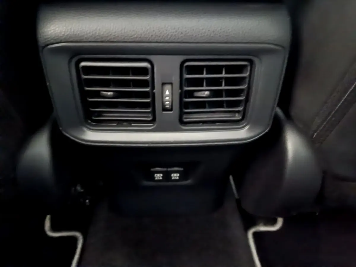 Gros plan sur les aérateurs arrière noirs et prises USB du Toyota RAV4 gris clair, intérieur arrière passager.