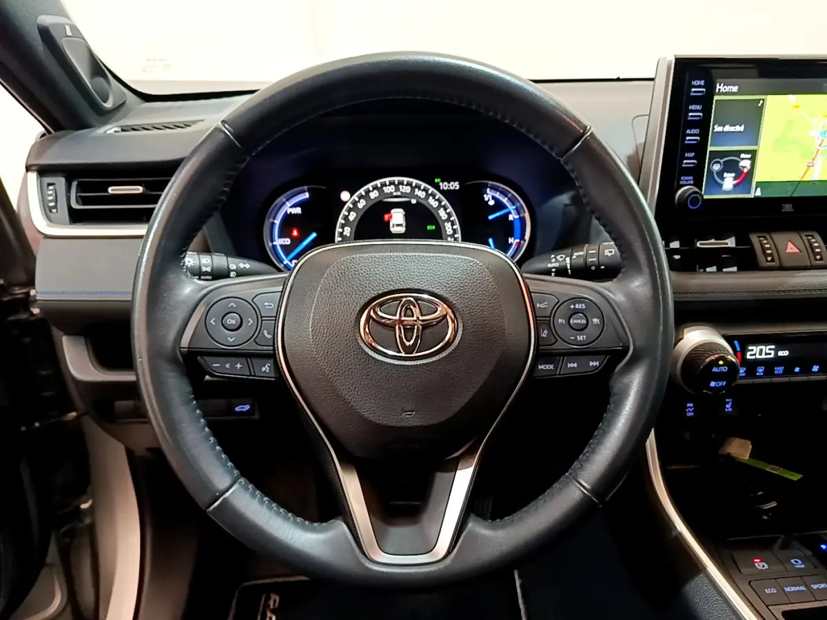 Vue rapprochée du volant cuir noir Toyota RAV4 2WD 218ch Collection 2019 avec tableau de bord et écran tactile visible.