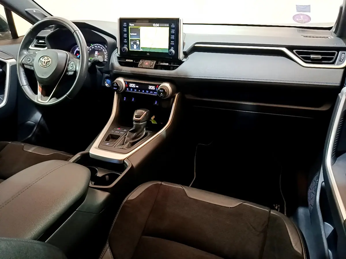 Intérieur du Toyota RAV4 2019 vu de l'avant droit, tableau de bord noir avec écran tactile et volant cuir.