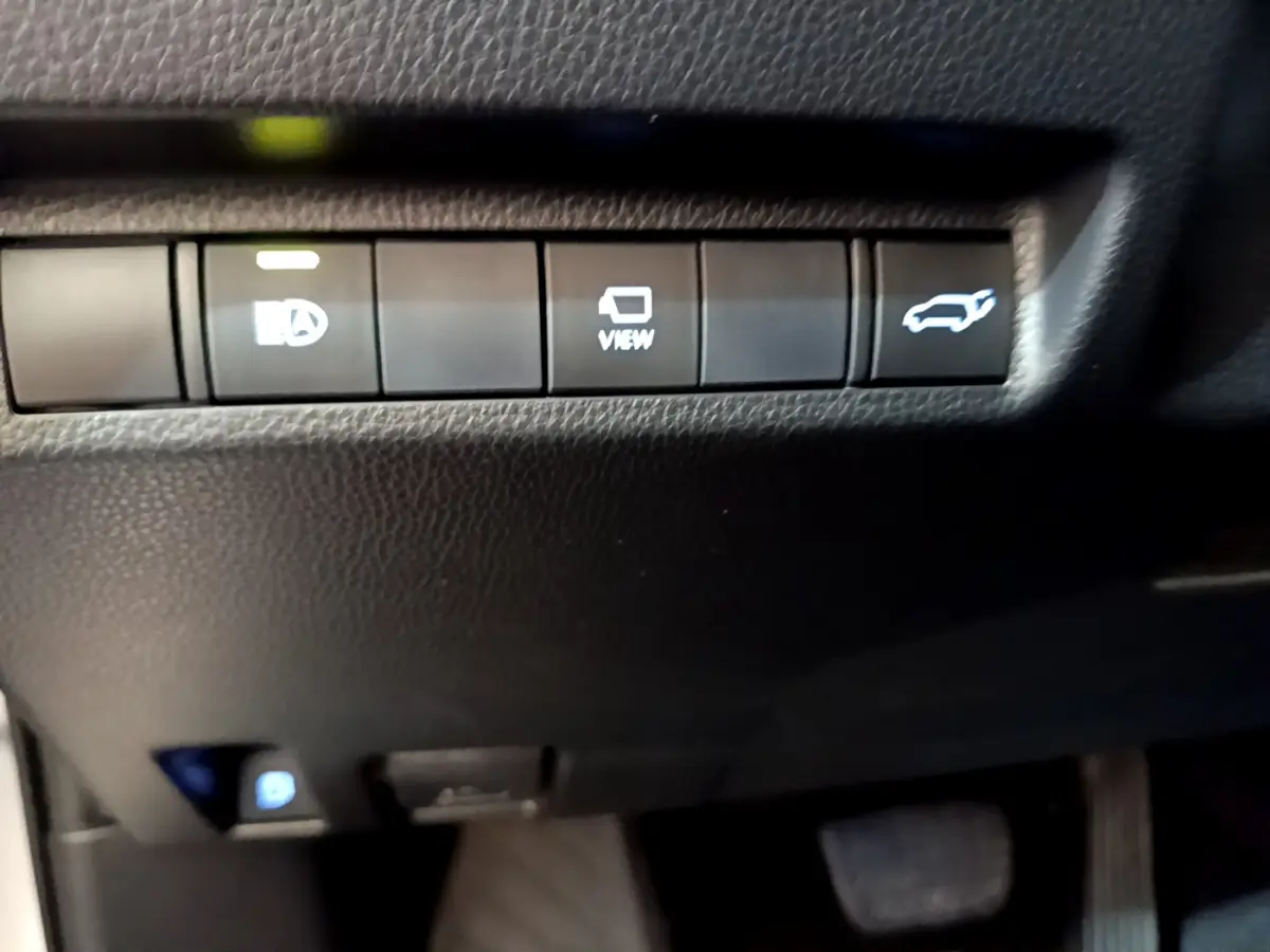 Boutons de commande du tableau de bord noir du Toyota RAV4 gris clair, avec fonction ouverture coffre et affichage caméra.