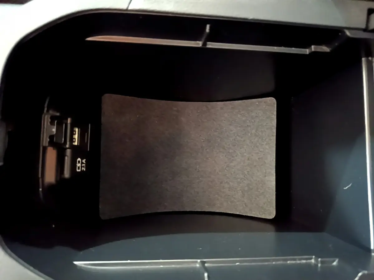 Vue intérieure du compartiment de rangement central noir du Toyota RAV4 gris clair 2019, avec prise USB visible à gauche