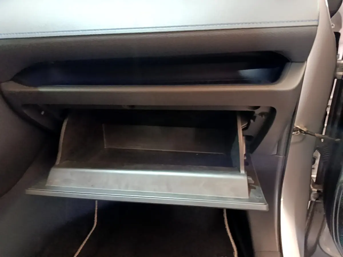 Gros plan sur la boîte à gants ouverte côté passager du Toyota RAV4 gris clair 2WD 2019.