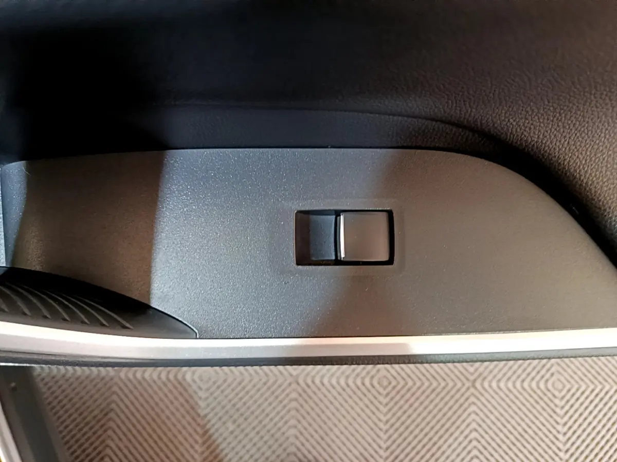 Gros plan sur l'interrupteur de réglage électrique du siège côté conducteur d'un Toyota RAV4 gris clair 2019.