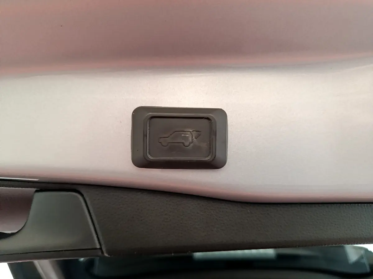Bouton d'ouverture électrique du coffre sur la partie intérieure du hayon du Toyota RAV4 gris clair 2019.