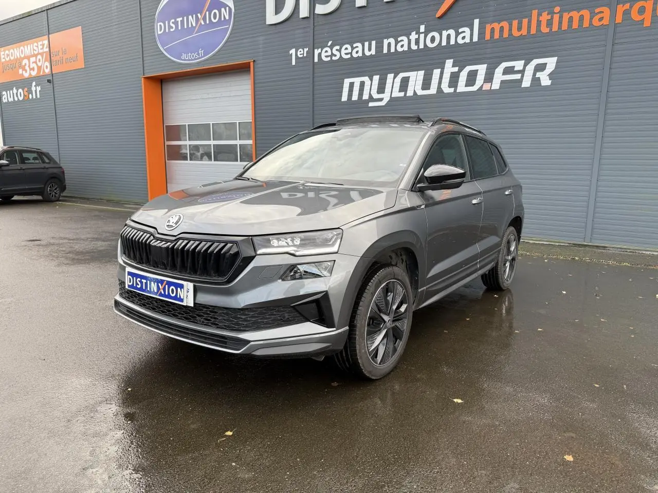 SKODA KAROQ 1.5 TSI Sportline gris graphite métallisé en 3/4 avant avec jantes alliage et toit panoramique.