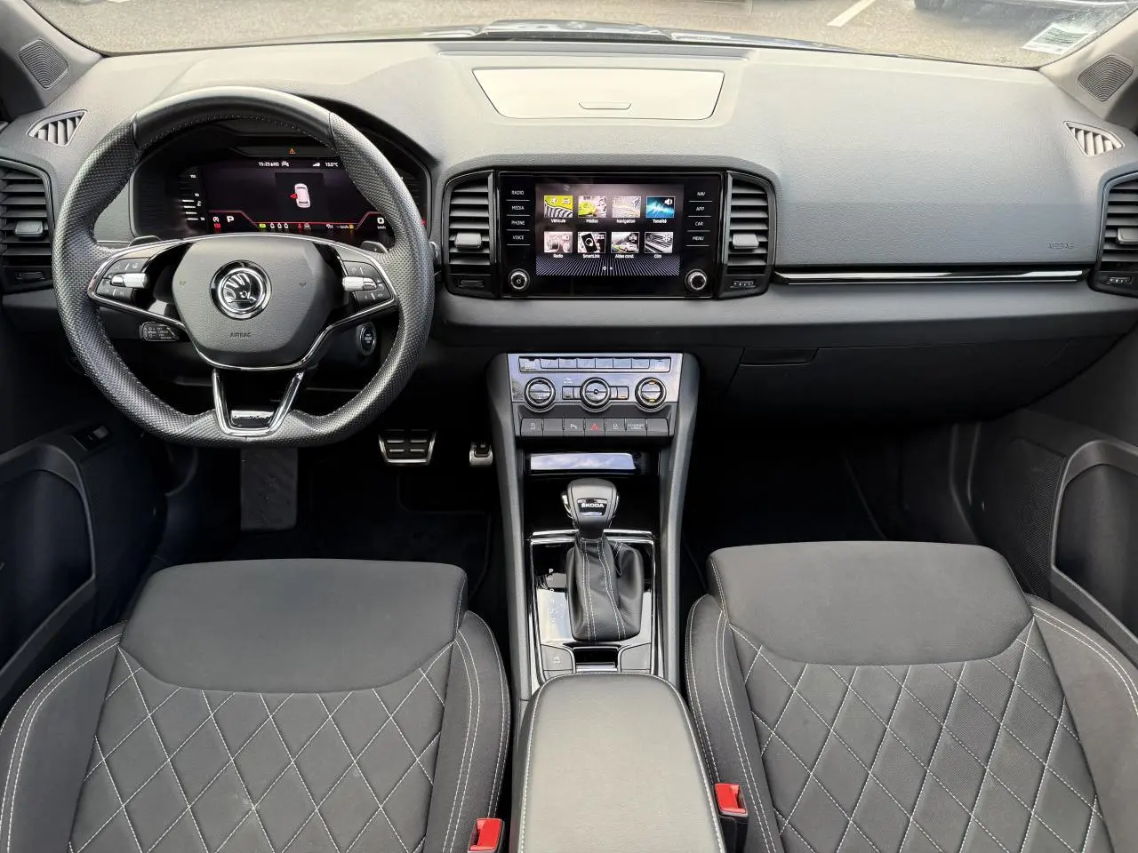 Intérieur noir du Skoda Karoq 2023 vu de face, avec tableau de bord digital et console centrale moderne.