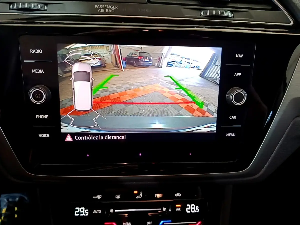 Écran tactile central du Volkswagen Touran 2023 montrant l’aide au stationnement arrière avec guidage couleur.