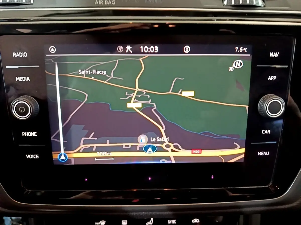 Écran tactile central du Volkswagen Touran 2023 affichant la navigation avec carte et commandes autour en noir brillant.