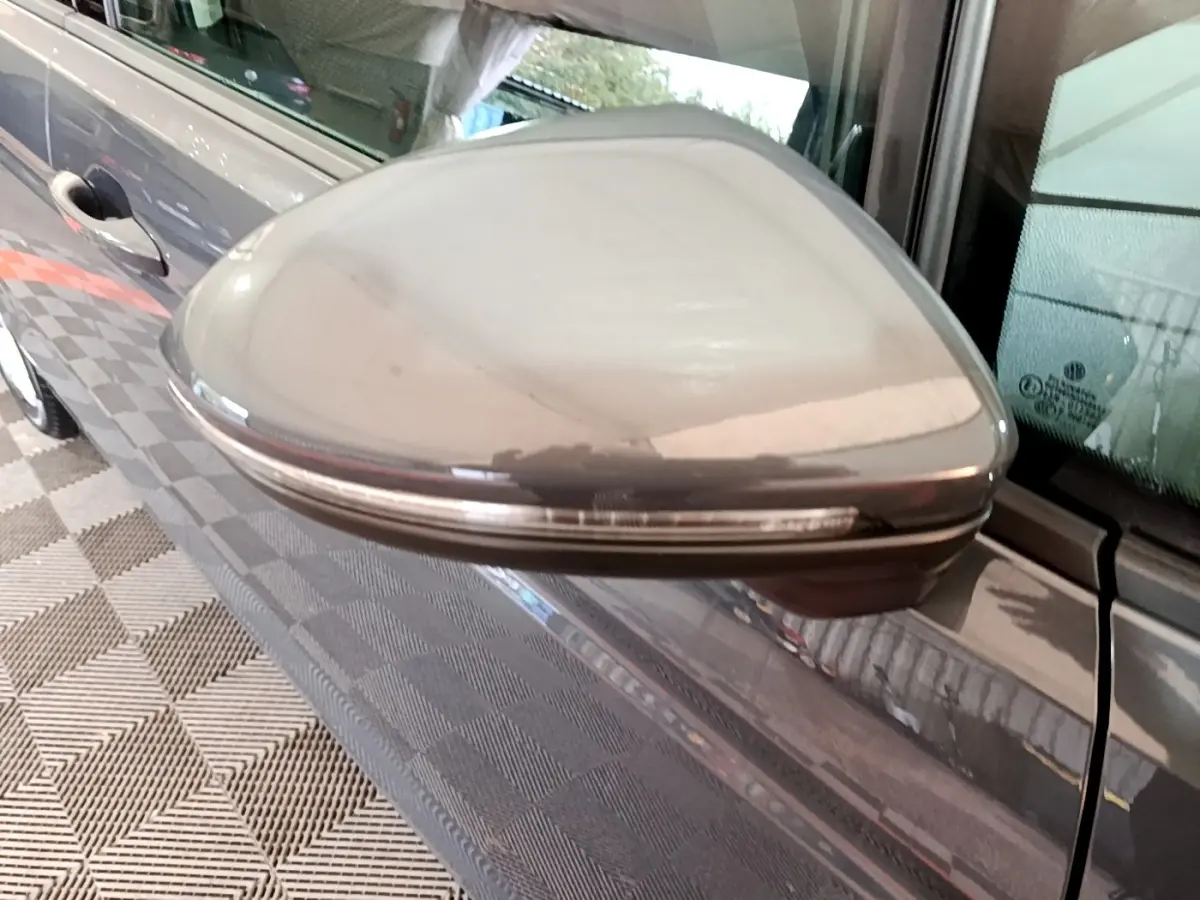 Rétroviseur droit gris foncé du Volkswagen Touran 2023 avec clignotant intégré, vue rapprochée en extérieur.