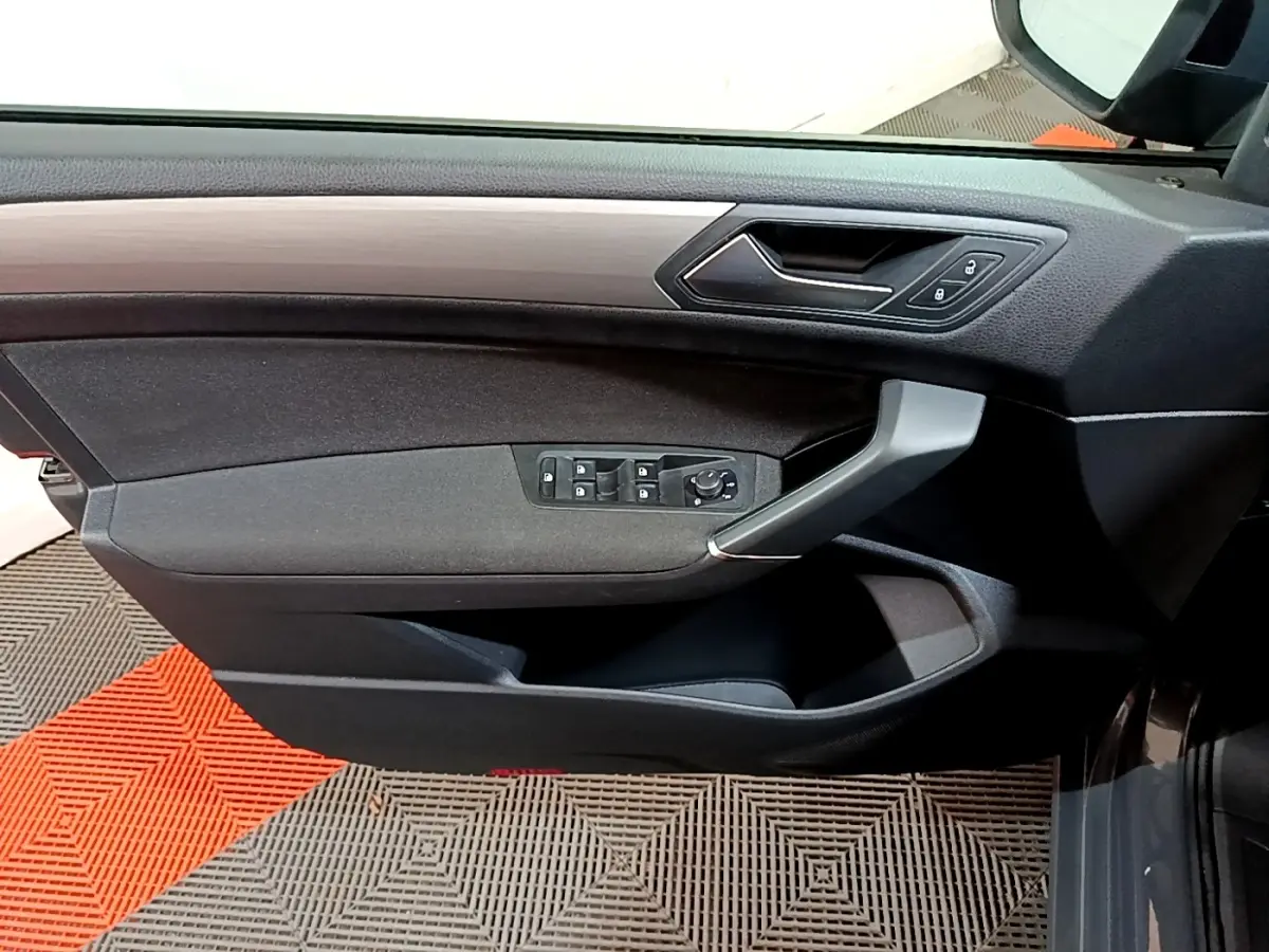 Vue intérieure côté gauche de la porte conducteur du Volkswagen Touran gris foncé avec commandes de vitres et verrouillage.