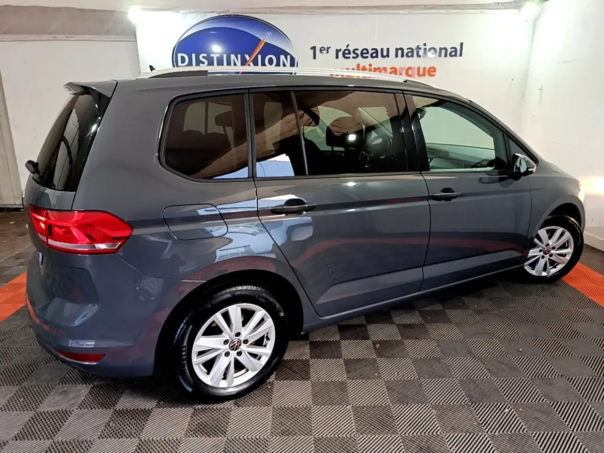 Vue latérale droite d'un Volkswagen Touran gris foncé 2023 avec jantes alliage et vitres teintées.