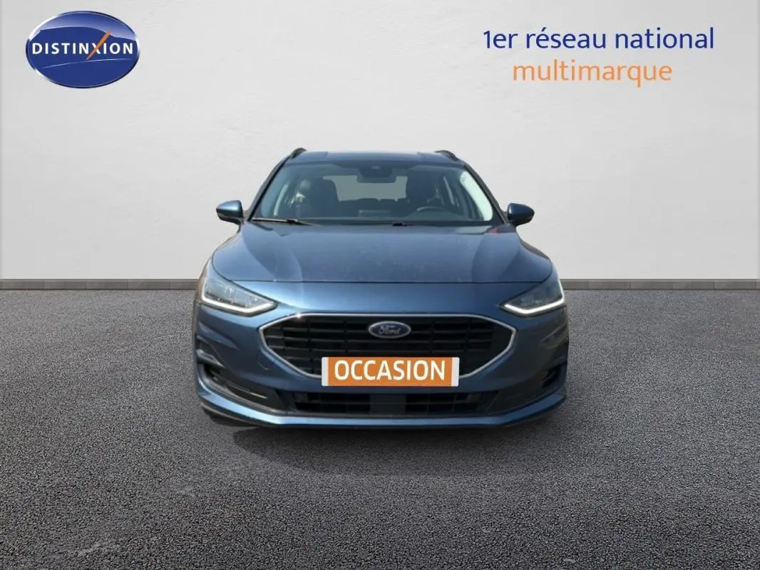 Vue frontale d'une Ford Focus SW bleu foncé 2022 avec calandre noire et phares LED allumés.