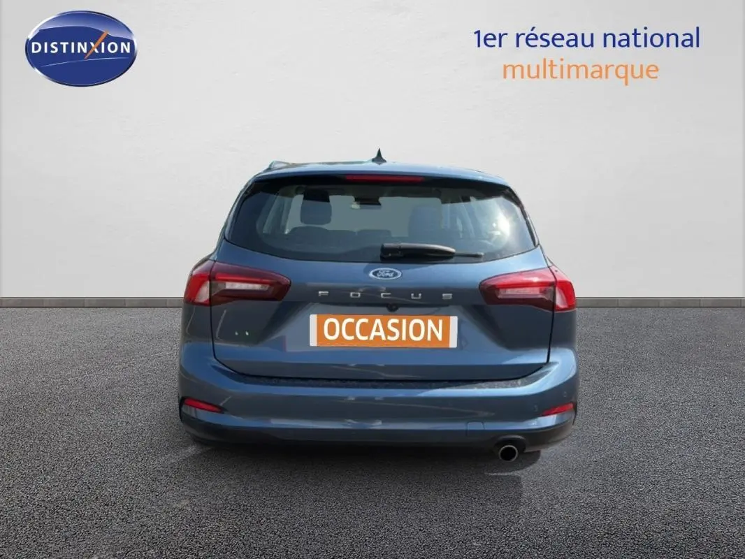Vue arrière d'une Ford Focus SW bleu foncé de 2022 avec feux rouges et plaque "OCCASION" visible.