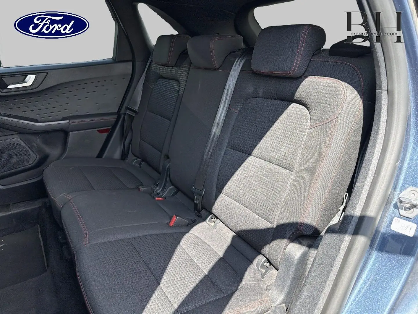 Vue intérieure côté droit sur la banquette arrière tissu noir avec surpiqûres rouges du Ford Kuga bleu 2020.