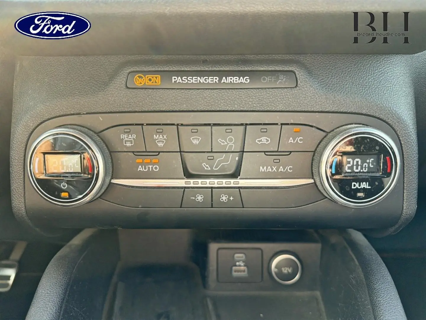 Vue rapprochée de la console centrale du Ford Kuga 2020, montrant la climatisation bi-zone et les commandes digitales.