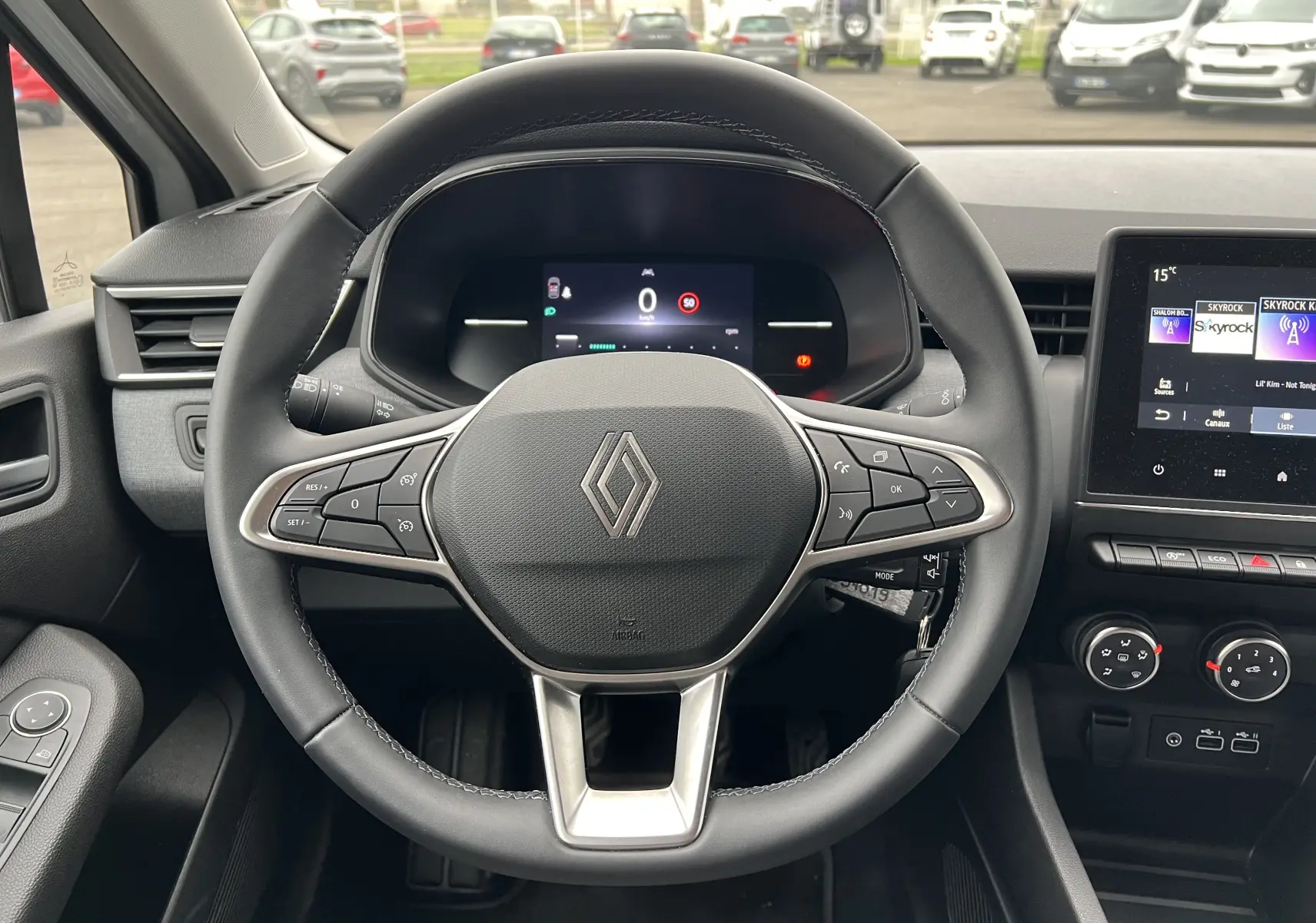 Vue intérieure centrée sur le volant cuir de la Renault Clio V 1.0 Tce 90 Evolution avec tableau de bord numérique et écran tactile.