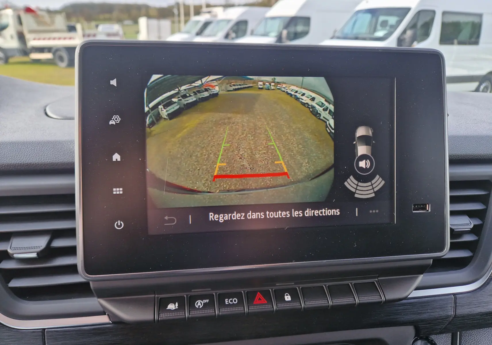 Vue de l'écran de caméra de recul du Nissan Primastar gris urbain, affichant le parking derrière le véhicule.