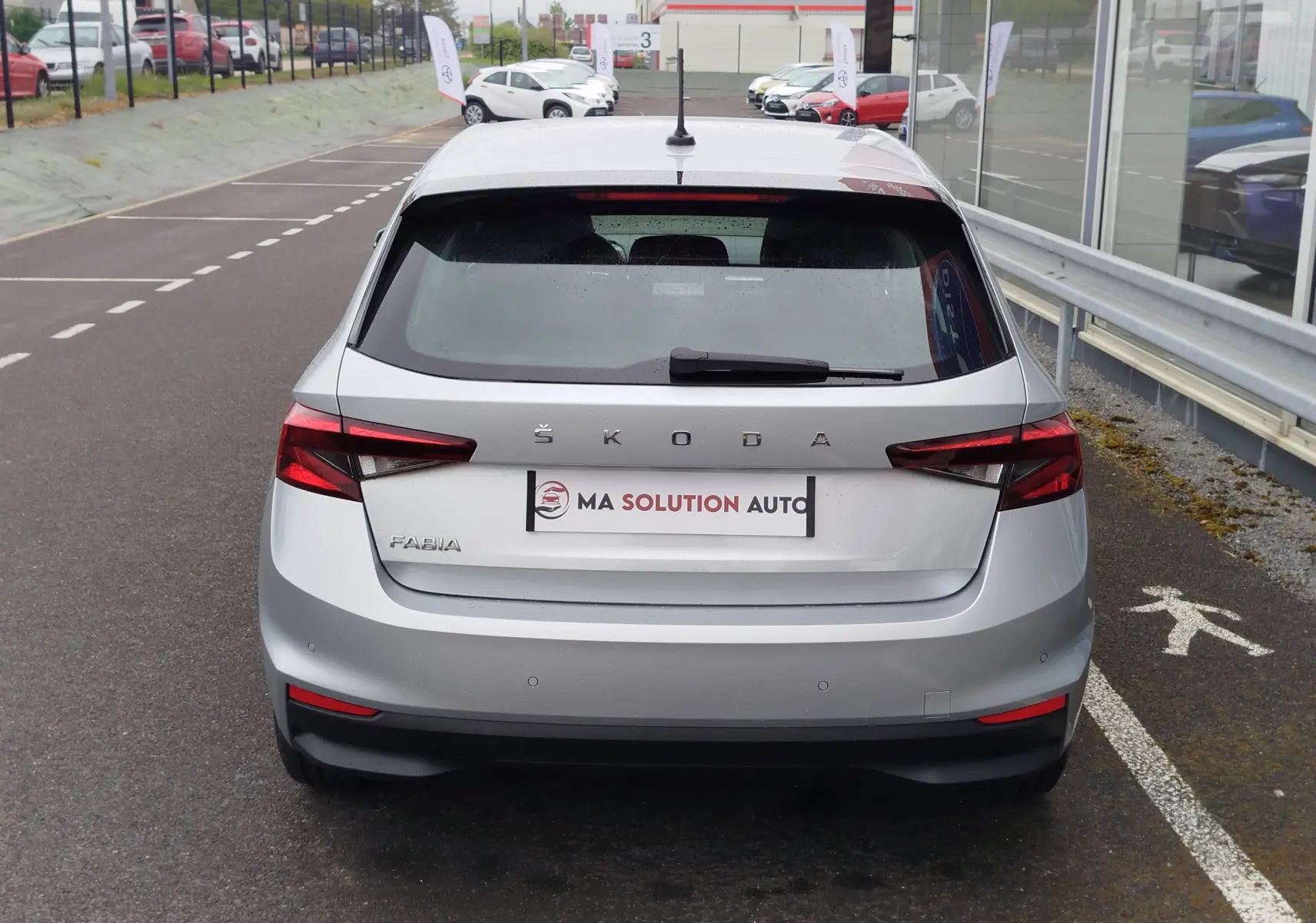 Vue arrière d'une Skoda Fabia gris argent métallisé 2023 avec feux arrière LED et logo ŠKODA bien visible.