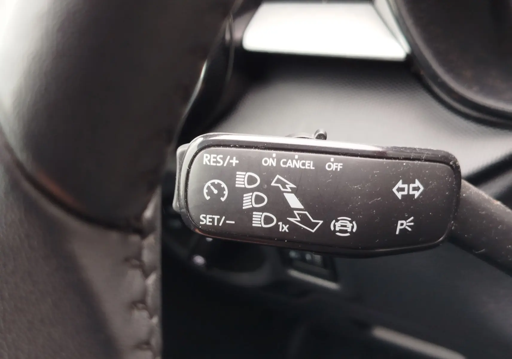 Gros plan sur la manette de commande du régulateur de vitesse et des feux dans un Skoda Fabia gris argent 2023.