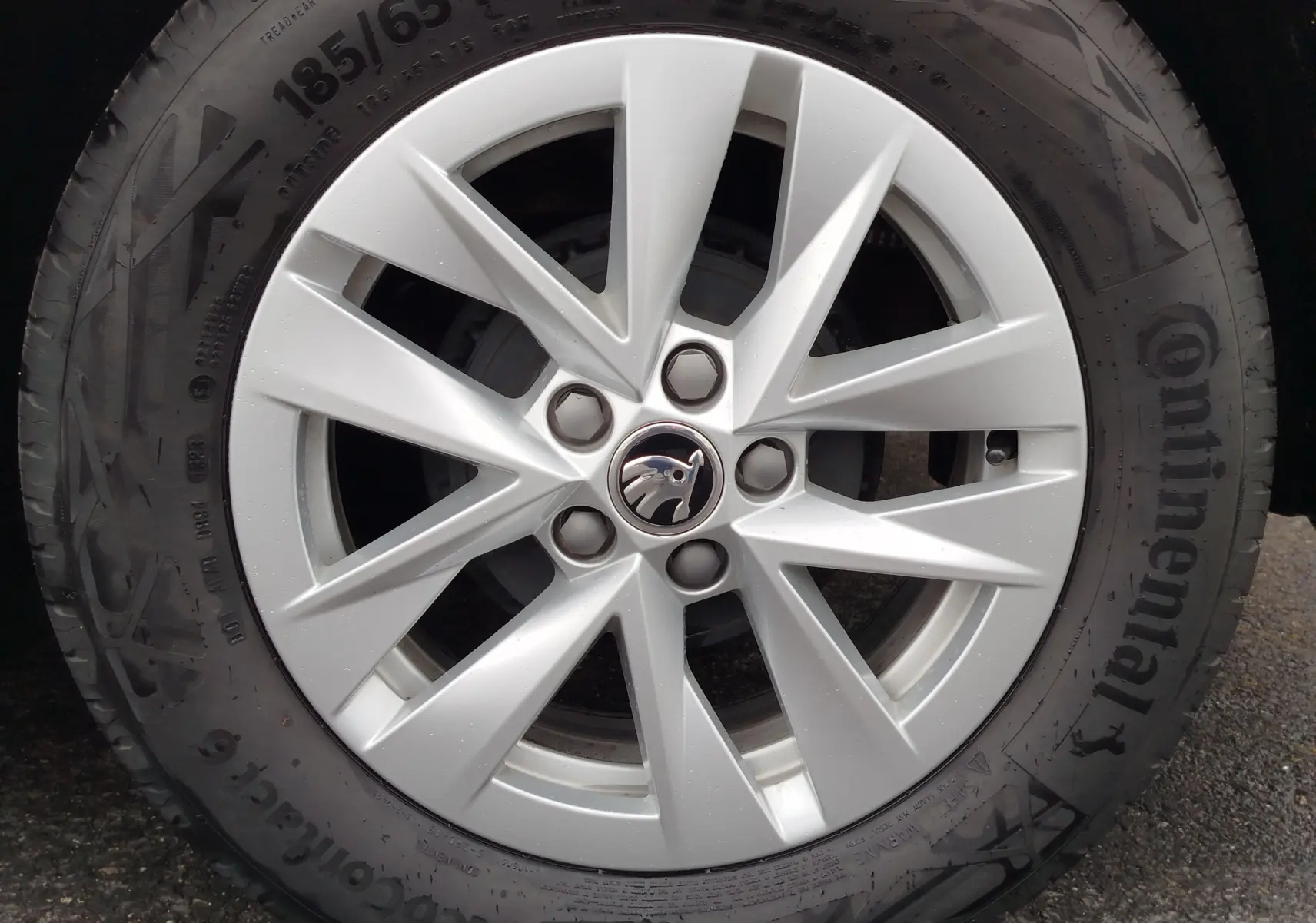 Gros plan sur la jante argentée à 10 branches d'une roue Continental d'une Skoda Fabia gris argent métallisé.