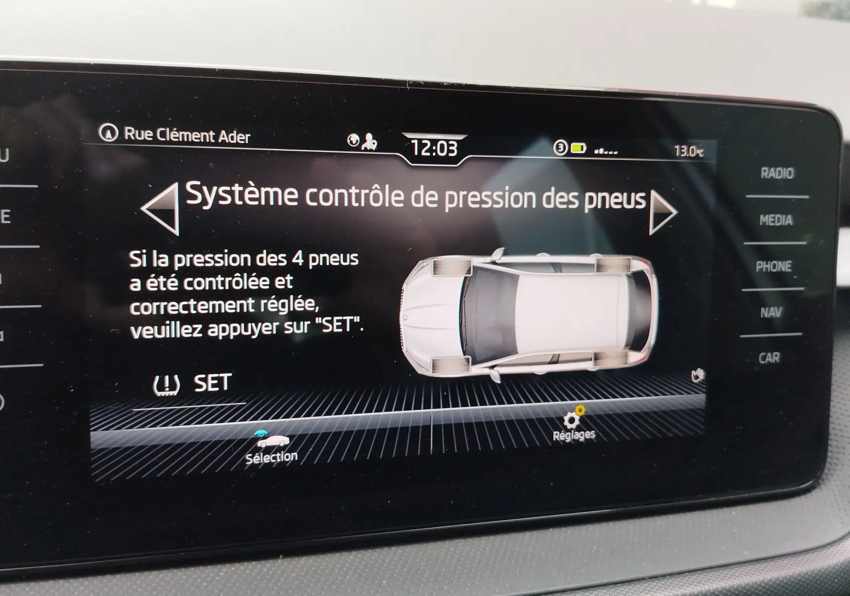 Écran central affichant le système de contrôle de pression des pneus sur une Skoda Fabia gris argent, vue intérieure.