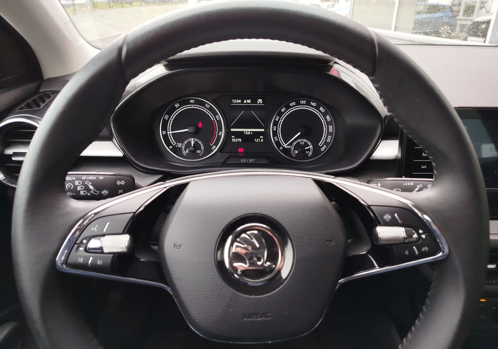 Vue intérieure centrée sur le volant noir et le tableau de bord numérique de la Skoda Fabia 2023.