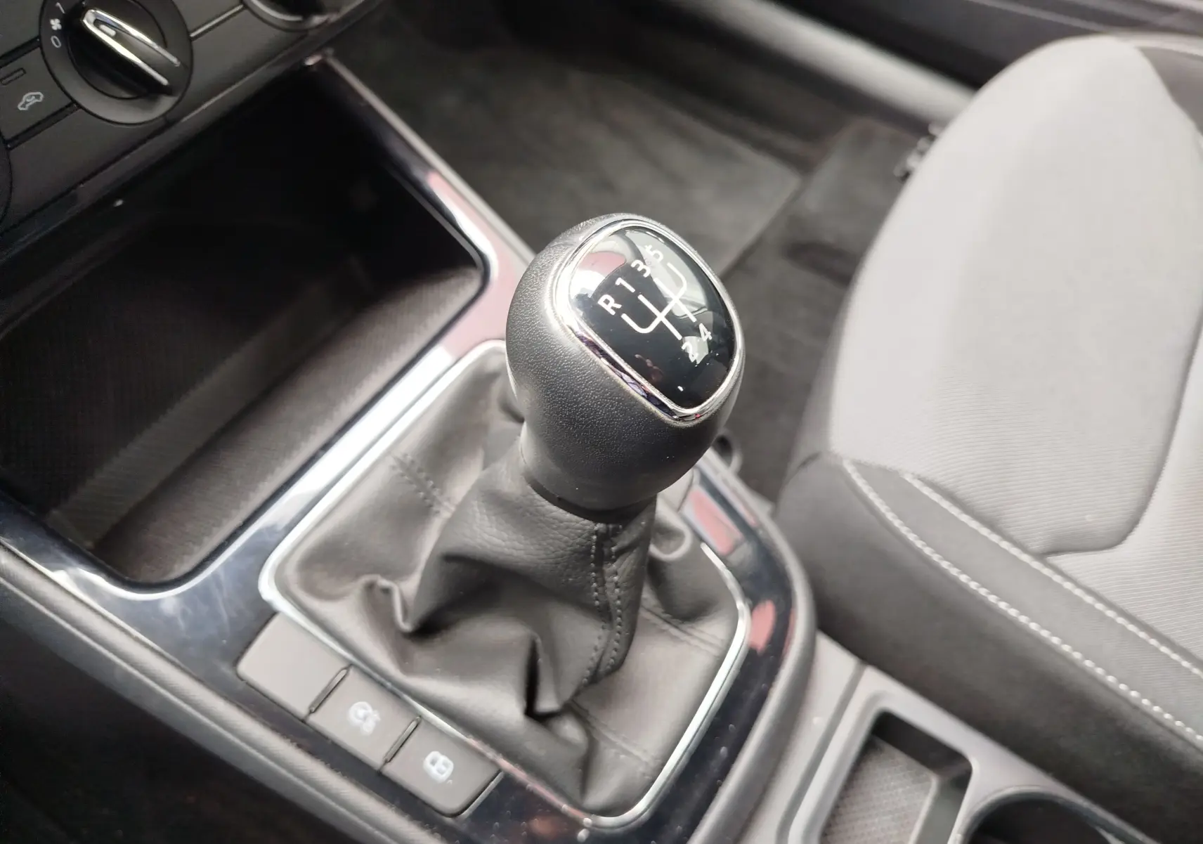 Gros plan sur le levier de vitesses manuel noir et gris de la Skoda Fabia 2023, intérieur tissu gris clair.