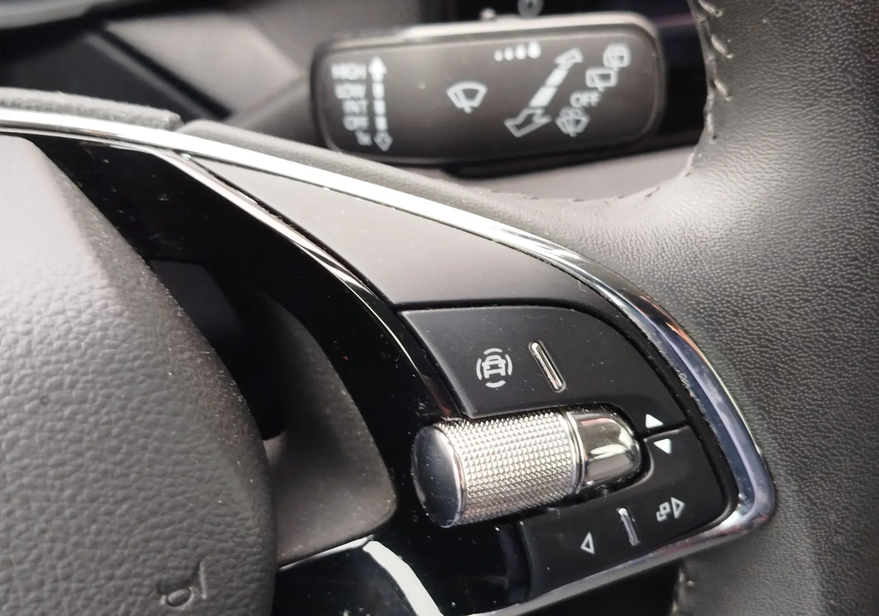 Gros plan sur les commandes du volant de la Skoda Fabia 2023, finition Ambition, avec molette métallique et boutons noirs.