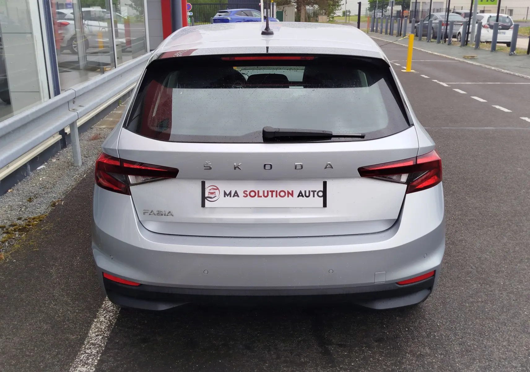 Vue arrière d'une Skoda Fabia gris argent métallisé 2023, avec feux arrière LED et logo ŠKODA visible.