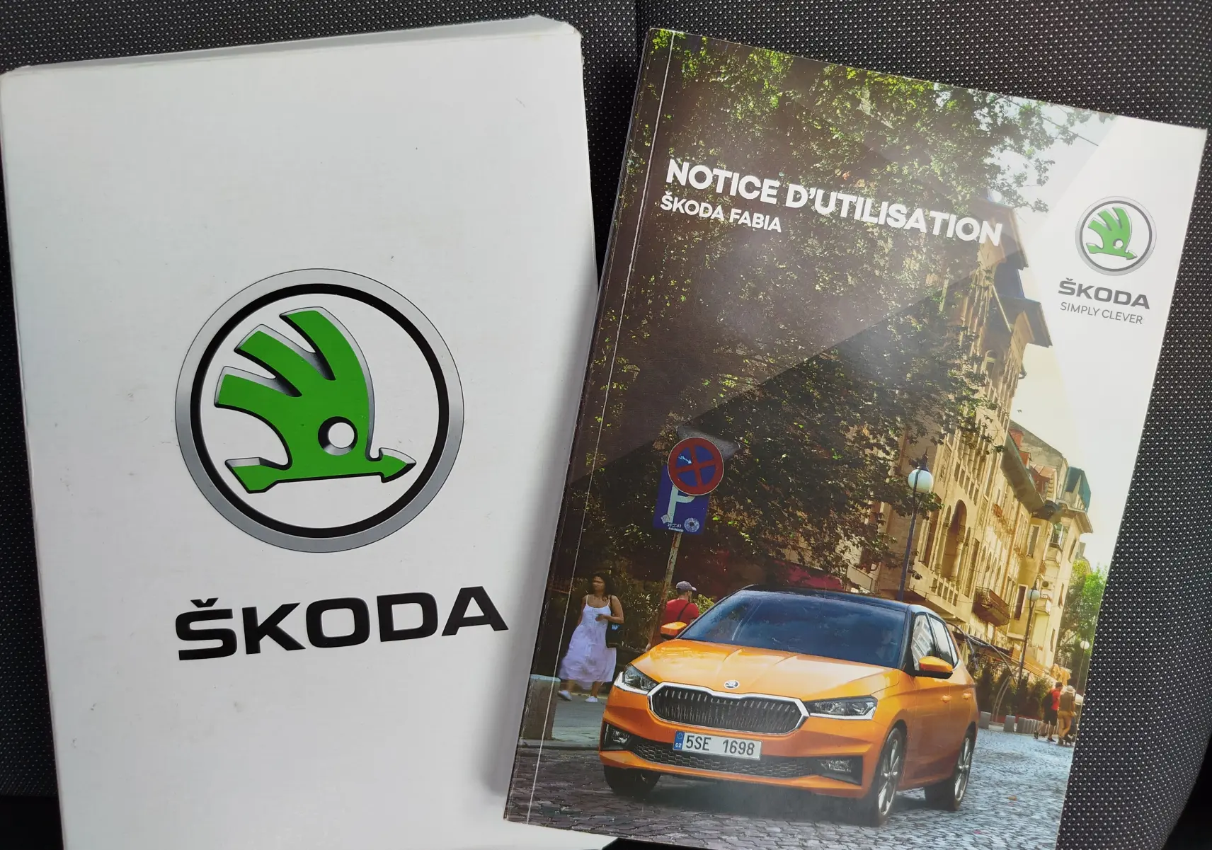 Manuel d'utilisation Škoda Fabia avec photo d'une Fabia orange vue de face dans une rue pavée en ville.
