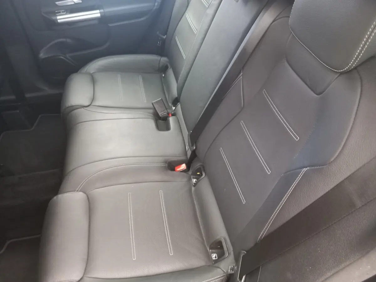 Vue intérieure sur la banquette arrière en cuir noir avec surpiqûres blanches de la Mercedes Classe A Berline AMG Line 2021.