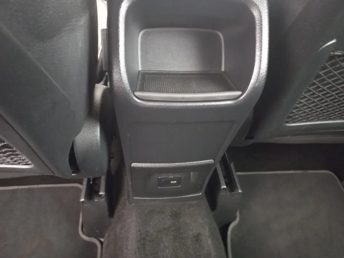 Vue rapprochée de la console centrale arrière noire de la Mercedes Classe A Berline A 200 AMG Line avec prise USB visible.