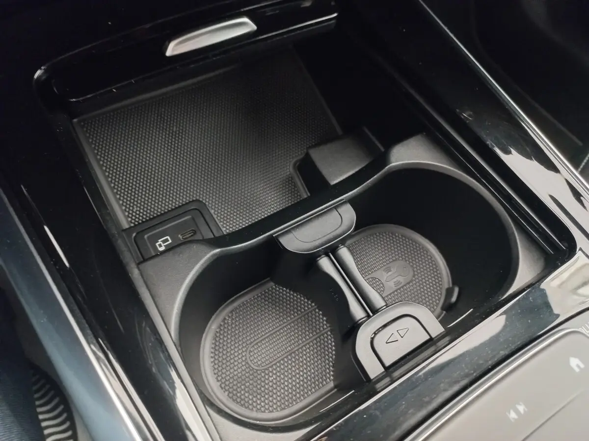 Gros plan sur le porte-gobelets et la zone de recharge sans fil intérieure de la Mercedes Classe A A 200 AMG Line noire.