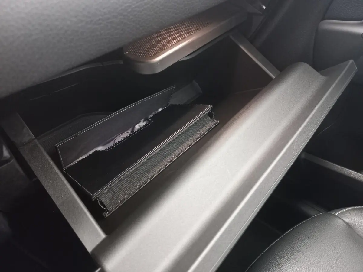Vue rapprochée de la boîte à gants ouverte de la Mercedes Classe A A 200 AMG Line 2021 avec un étui noir à l'intérieur.
