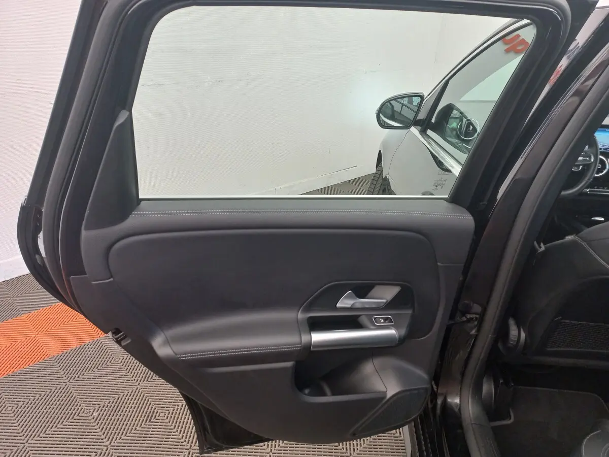 Vue intérieure sur la porte arrière gauche noire d’une Mercedes Classe A Berline A 200 AMG Line 2021.