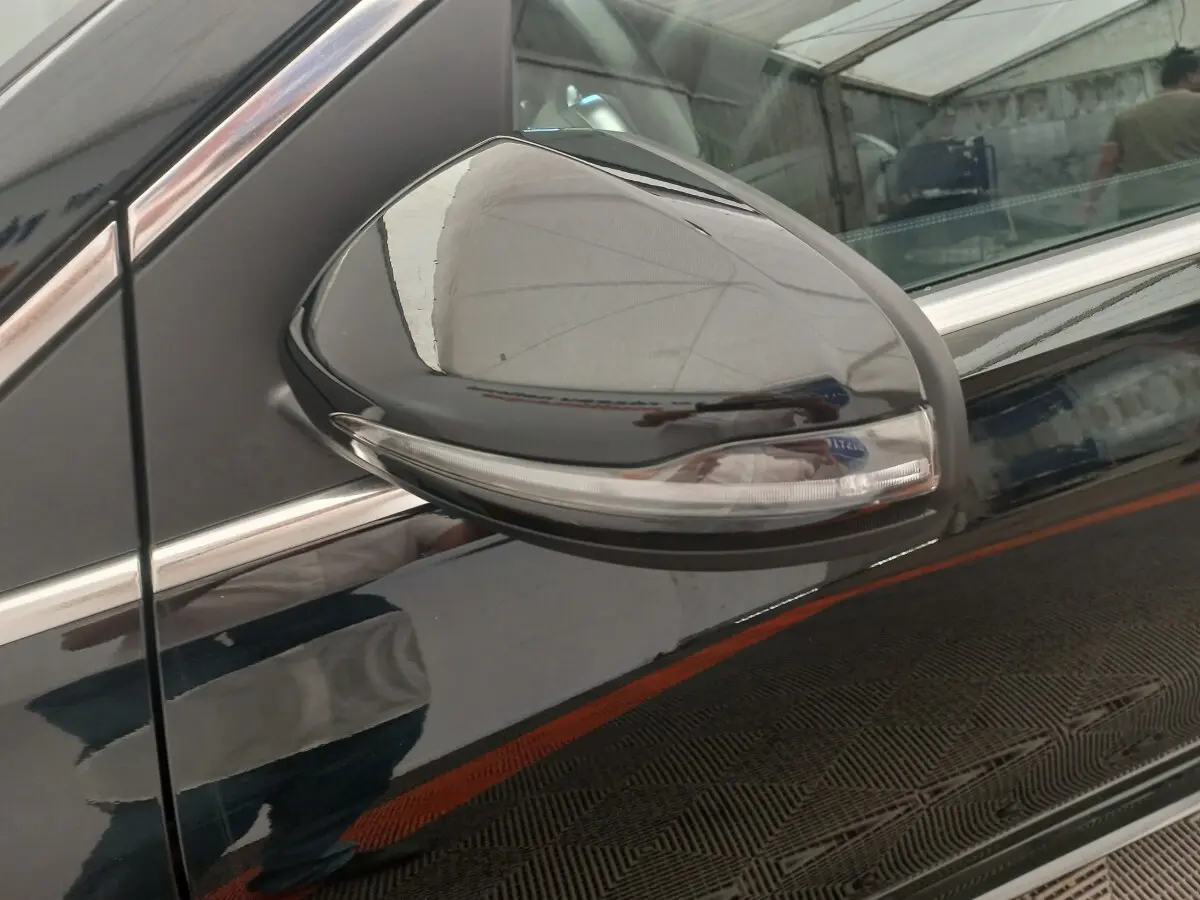 Gros plan sur le rétroviseur droit noir brillant avec clignotant intégré d'une Mercedes Classe A Berline A 200 AMG Line 2021.