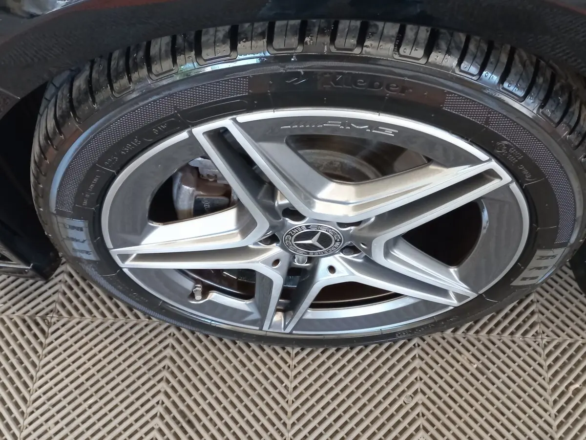 Gros plan sur la jante AMG argentée et le pneu noir d'une Mercedes Classe A Berline A 200 AMG Line 2021.