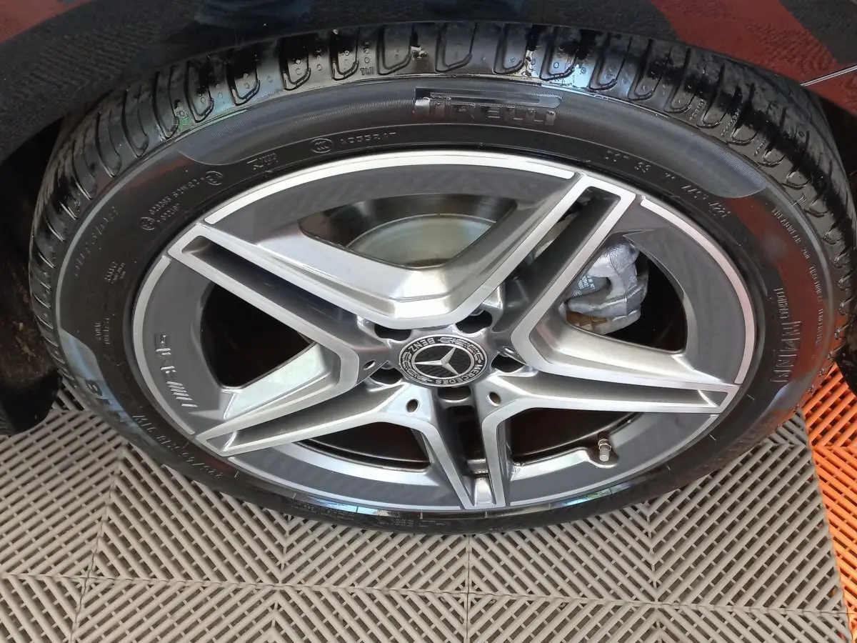 Gros plan sur la jante alliage AMG à cinq branches de la Mercedes Classe A Berline noire, avec logo central visible.