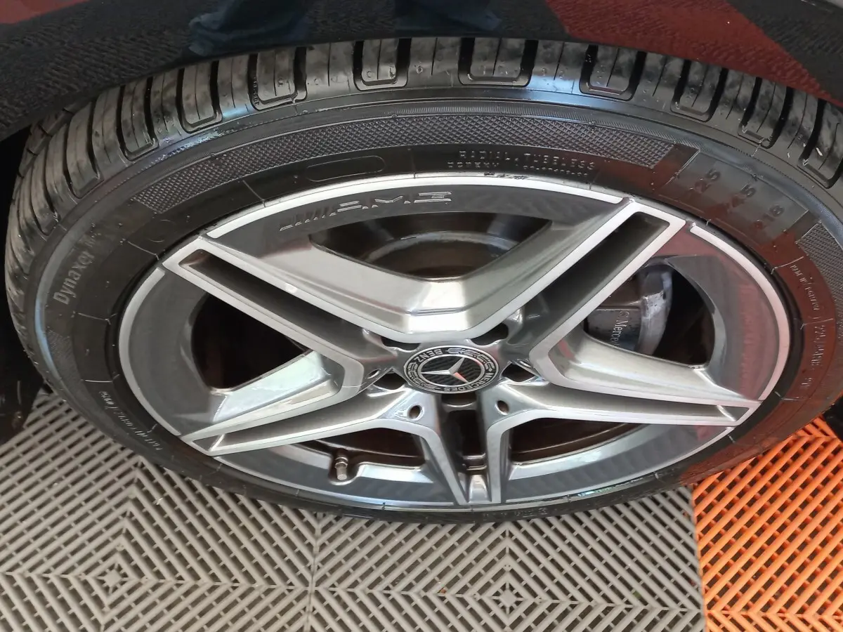 Gros plan sur la jante AMG argentée et le pneu noir d'une Mercedes Classe A berline A 200 AMG Line.